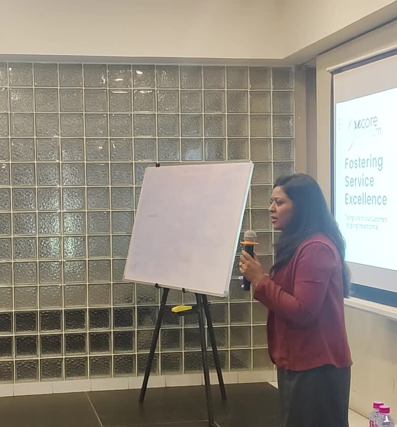 Sumita Singh speaking to a seated group with a microphone
